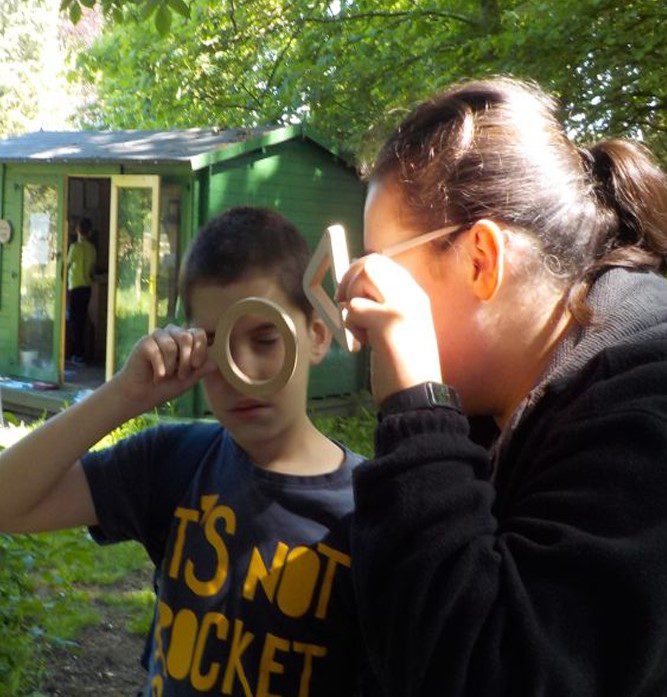 boy and woman looking through magnifying glasses