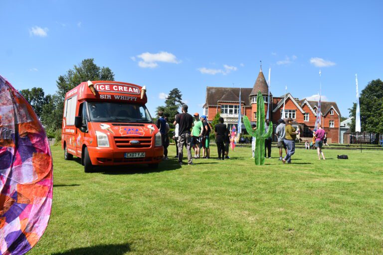 ice cream van with queue leading to side of it