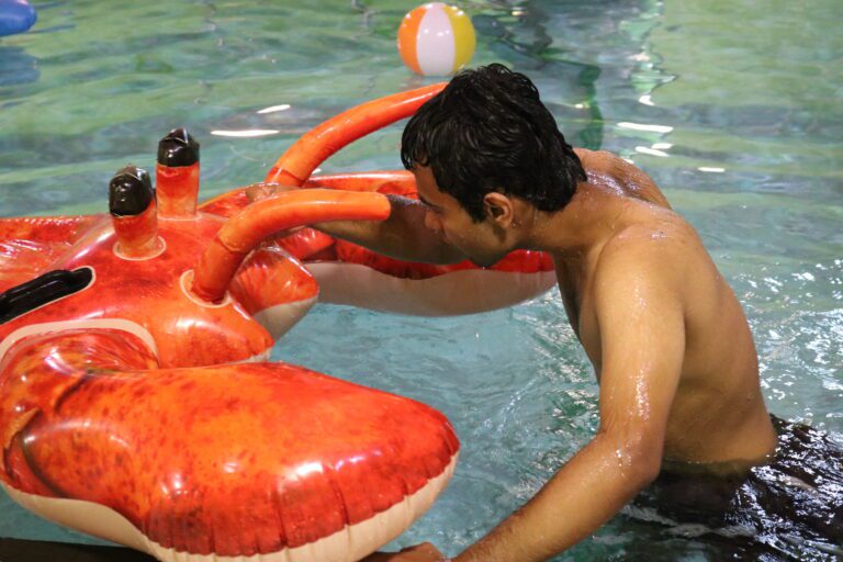 boy in water holding a massive inflatable lobster