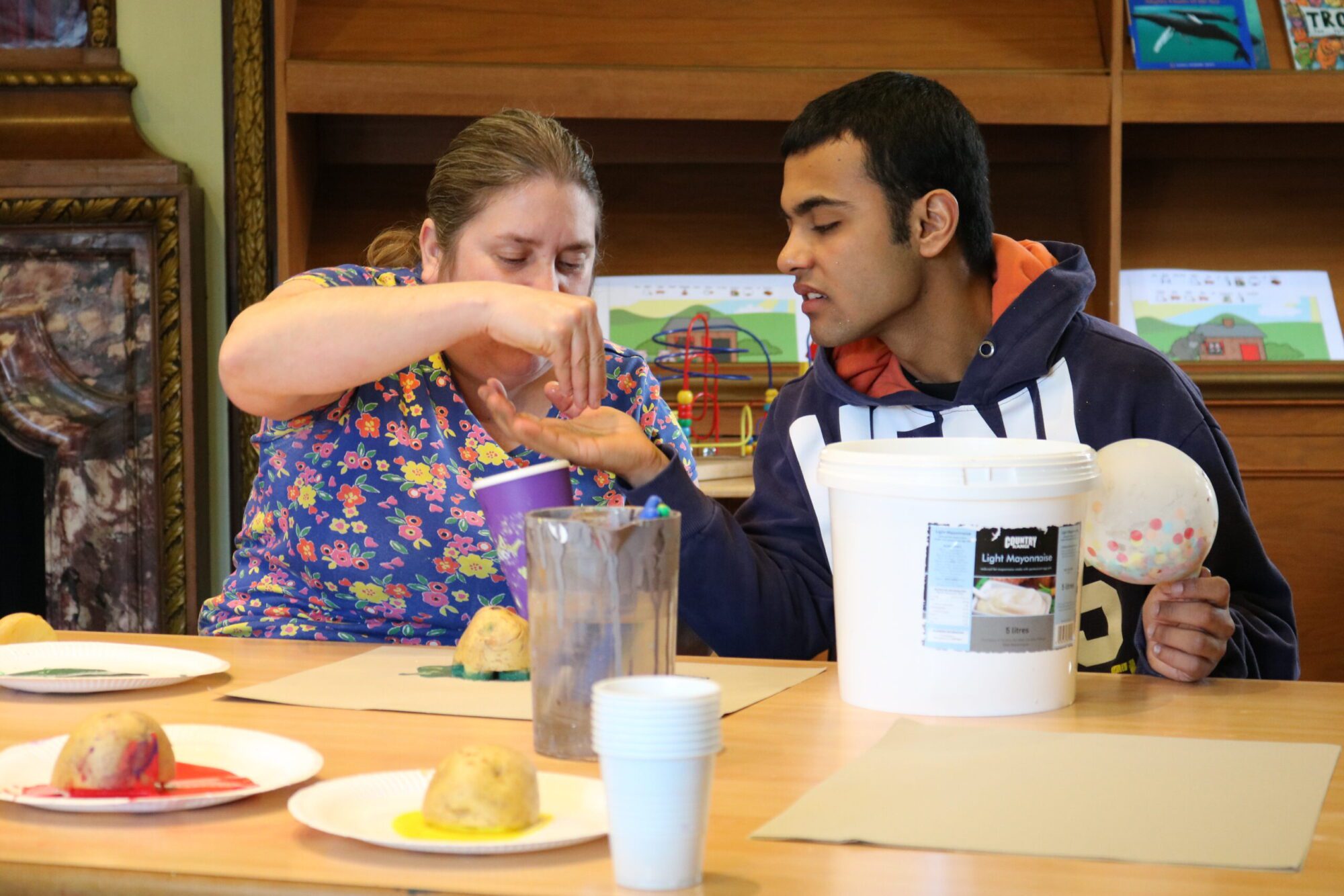 woman putting something into boys hand