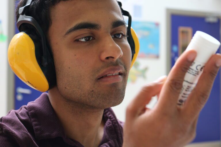 boy with headphones on holding glue
