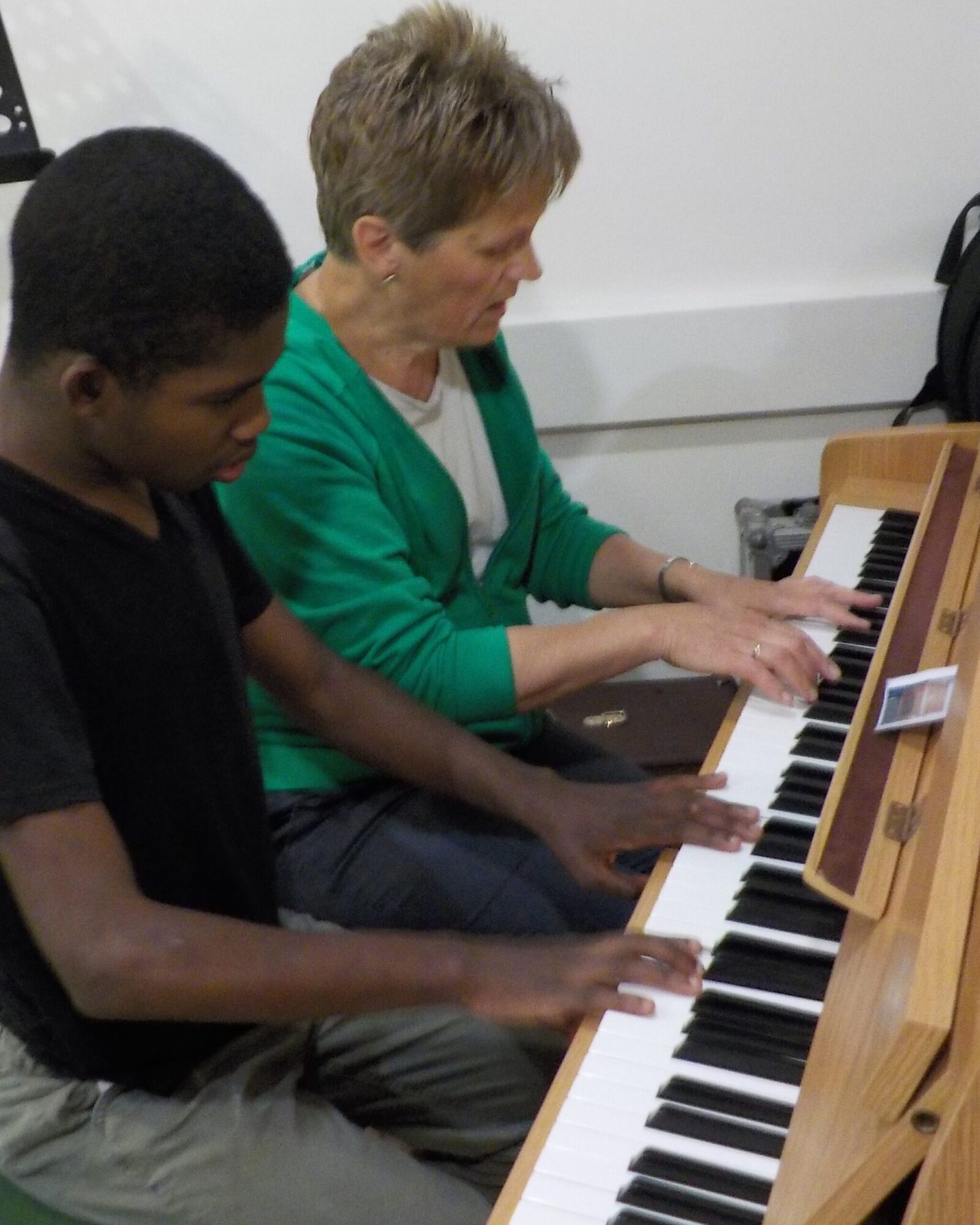 woman and boy playing a piano together